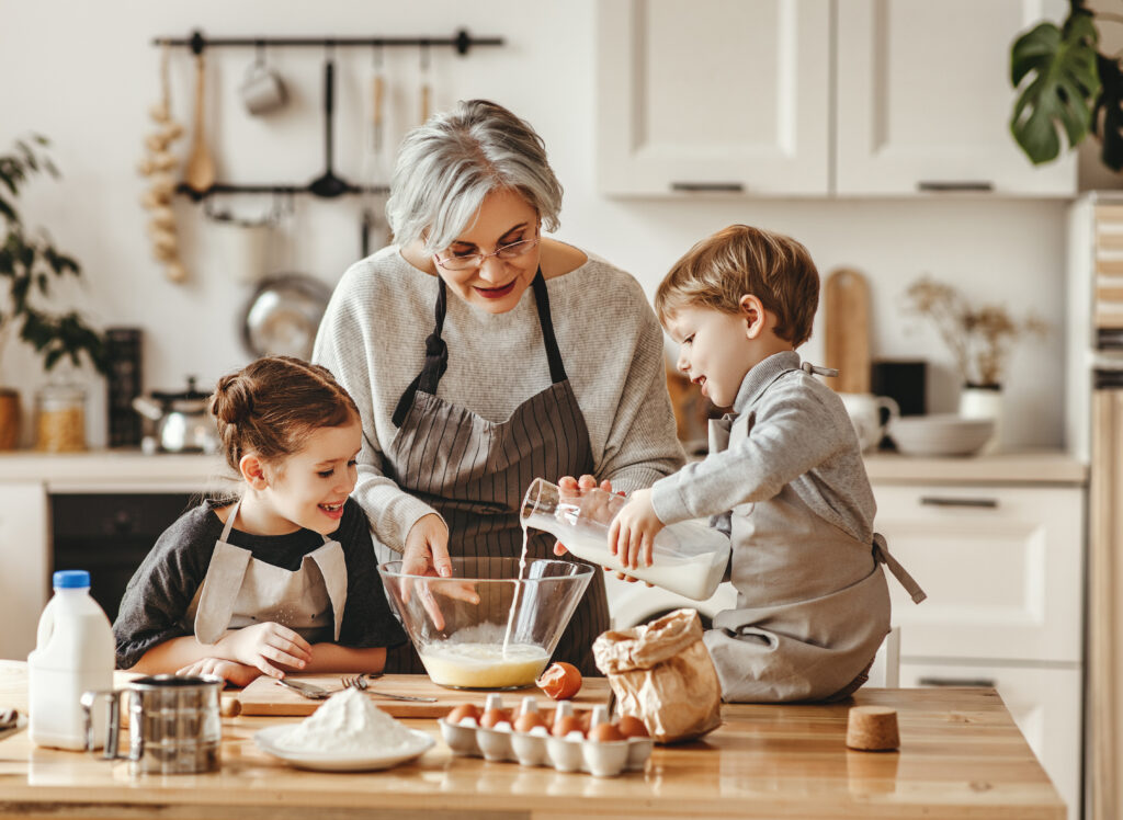 happy family grandmother and grandchildren cook in the kitchen, knead dough, bake cookies