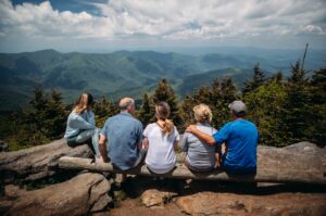 group of people sitting on rocks overlooking mountain